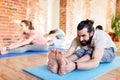 Group of people doing yoga forward bend at studio