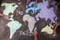 A group of people drawing with colored chalks on the floor with his hands in the street a map of the world Royalty Free Stock Photo