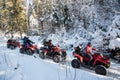 Group of people driving off-road four-wheelers ATV bikes in winter forest Royalty Free Stock Photo