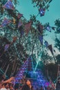 Group of people enjoying the Noisily Festival under a canopy of lights in vibrant colors.