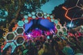 Group of people enjoying the Noisily Festival under a canopy of lights in vibrant colors.