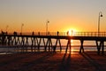 Group of people enjoying a stroll along a boardwalk at sunset in Glenelg Beach, Adelaide, Australia Royalty Free Stock Photo