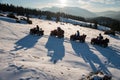 Group of people enjoying sunset, on off-road four-wheelers ATV bikes on snow in the the mountains in winter Royalty Free Stock Photo