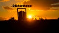 a group of people in a field near a large tower Royalty Free Stock Photo