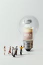 Group of people figurine standing against the Coronavirus COVID-19 vaccine in bulb light