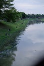 A group of people fishing by the river on the outskirts of the city