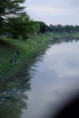 A group of people fishing by the river on the outskirts of the city