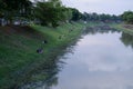 A group of people fishing by the river on the outskirts of the city