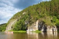 A group of people floating on the river in inflatable catamarans among the beautiful rocks and green coniferous forests