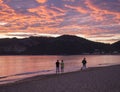 Group of people flying a drone during beautiful blue pink orange clouds sunset on Agios Georgios Pagon beach at Corfu Royalty Free Stock Photo