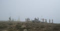 group of people in the fog on top of Mount Hoverla, Carpathians, Ukraine. Windy weather, gray cloud on top of the Royalty Free Stock Photo