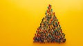 Group of People Forming a Christmas Tree Shape on a Yellow Background With Copy Space Royalty Free Stock Photo