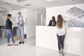 Group of people, four young businesspeople, meeting in modern office hallway, looking at papers Royalty Free Stock Photo