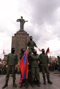 Group of people gathered around the Mother Armenia monument during a parade