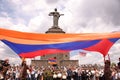 Group of people gathered around the Mother Armenia monument during a parade