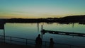 Group of people gathered on a dock at sunset, enjoying the breathtaking view of the the horizon Royalty Free Stock Photo