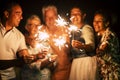Group of people have fun celebrating together new year eve or birthday with sparkles light and fireworks in friendship outdoor at