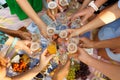 Group of people having outdoor picnic meal togetherness dining toasting glasses. Summer weekends Royalty Free Stock Photo