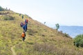 Group of people or hikers walking or trekking on a mountain hill forest.