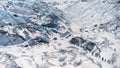 Tourists hiking on beautiful blue ice glacier covered with snow aerial view on a sunny winter day in Iceland