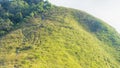 group of people hiking in landscape green glass of high hill mountain in elevation view