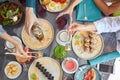 Group of people holding chopsticks and sampling asian food table with various kind of chinese food