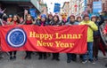 Group of people holding a festive banner "Happy Lunar New Year"