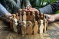 A group of people are holding hands in a circle around a wooden figure of a man Royalty Free Stock Photo
