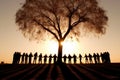 A group of people, holding hands, stand around a tree. The concept of caring for the environment