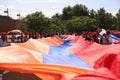 Group of people holding a large flag of Armenia during a parade