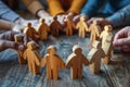 A group of people holding wooden figures in a circle Royalty Free Stock Photo