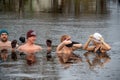 Group of people ice bathing together in the cold water of a lake in Preili, Latvia