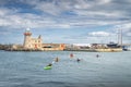 Group of people kayaking in Howth marina with Howth Lighthouse in background