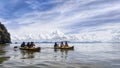 A group of people kayaking on the water with large limestone mountain range in the background Royalty Free Stock Photo