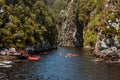 A group of people in Kayaks setting out up Storms River gorge, South Africa