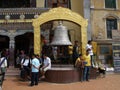 Group of people by a large bell at the Boudhanath stupa in Kathmandu, Nepal