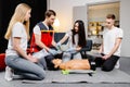 Group of people learning how to make first aid heart compressions with dummies during the training indoors Royalty Free Stock Photo