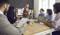 Group of people listening to a senior man while having a business meeting at work Royalty Free Stock Photo