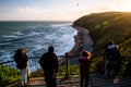 Group of people are looking at the view of the ocean at sunset