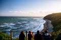 Group of people are looking at the view of the ocean at sunset