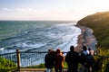 Group of people are looking at the view of the ocean at sunset