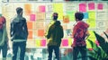 A group of people are looking at a wall of sticky notes The sticky notes are different colors and sizes The people are Royalty Free Stock Photo