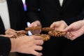 Group of people making chain of gears into collective form for harmony symbol.