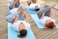Group of people making yoga exercises outdoors