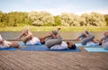 Group of people making yoga exercises outdoors