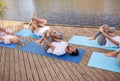 Group of people making yoga exercises outdoors