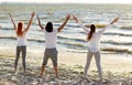 Group of people making yoga or meditating on beach Royalty Free Stock Photo