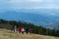 Group of people meditates on the nature overlooking the beautiful mountains