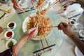 A group of people mixing and tossing Yee Sang dish with chop sticks. Royalty Free Stock Photo