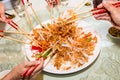 A group of people mixing and tossing Yee Sang dish with chop sticks. Yee Sang is a popular delicacy taken during Chinese New Royalty Free Stock Photo